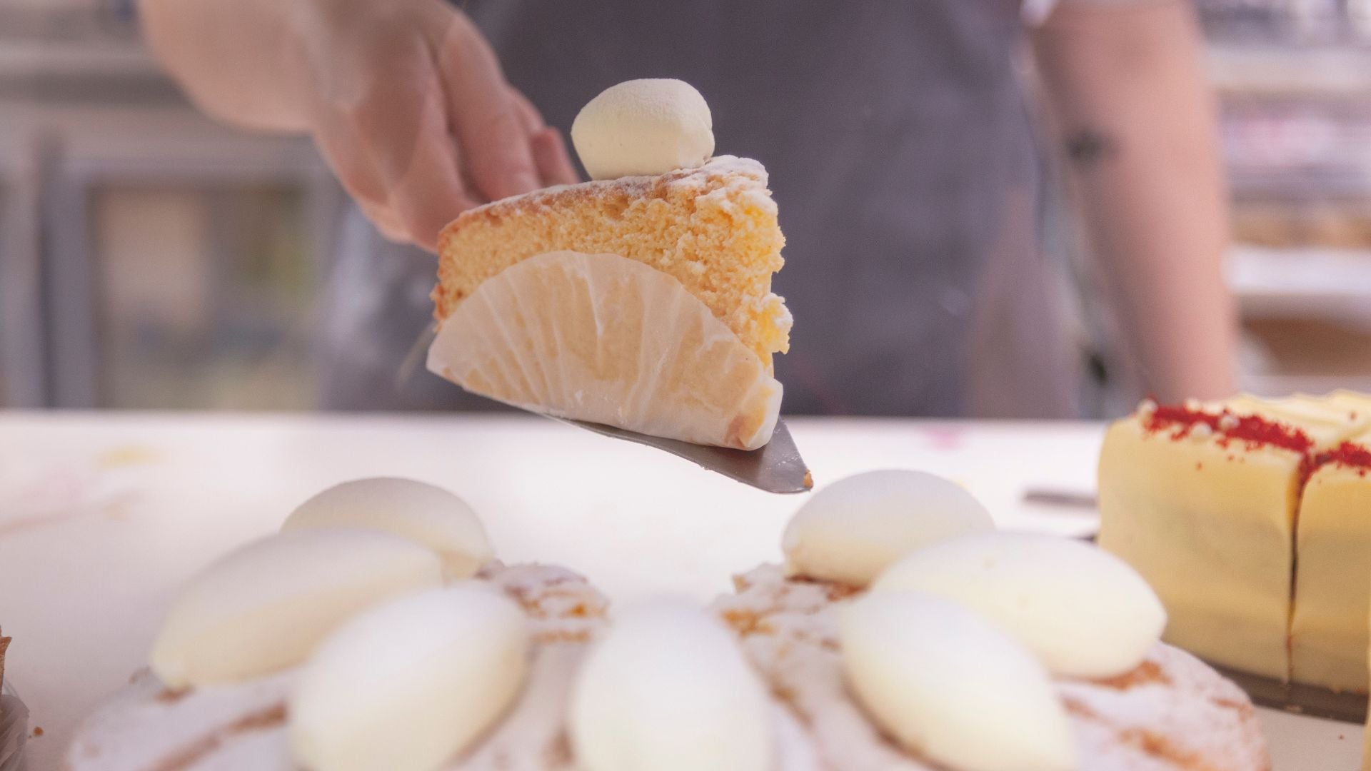 Person lifting a slice of Tres Leche cake at Candied Bakery