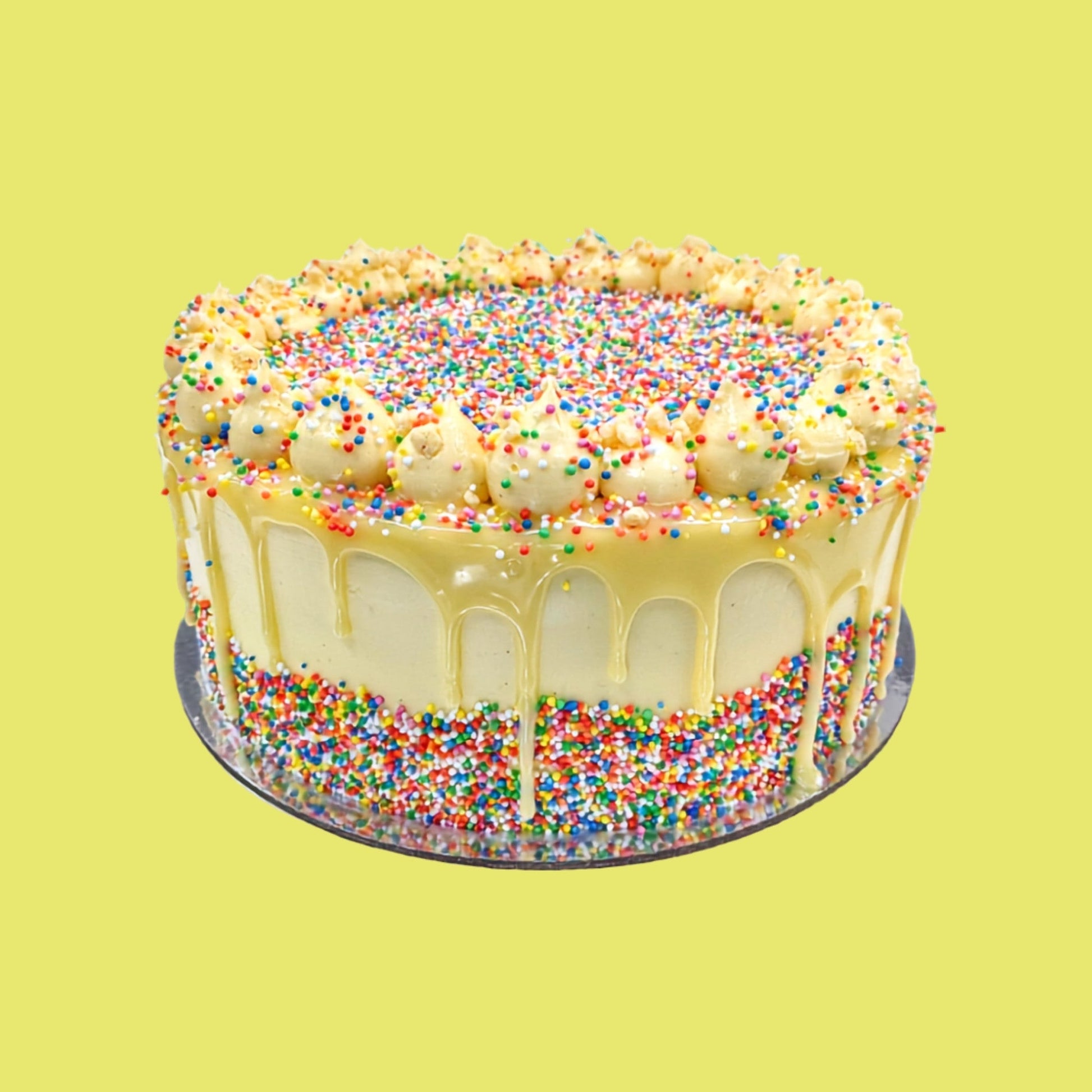 Colourful vanilla sprinkle cake with white chocolate drip and buttercream